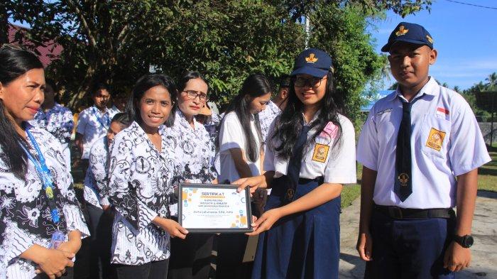 Tampak dua orang siswa SMP Manggala Perkasa menyerahkan pengghargaan apa Zelfia Latumaone sebagai guru yang Inovatif dan Kreatif