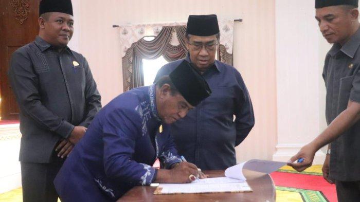 PEMERINTAH: Ketua DPRD Pulau Taliabu Muh Nuh Hasi teken SK dalam paripurna pemberhentian dan pengumuman hasil penet Bupati dan Wakil Bupati Pulau Taliabu terpilih, Jumat (9/5/2025)