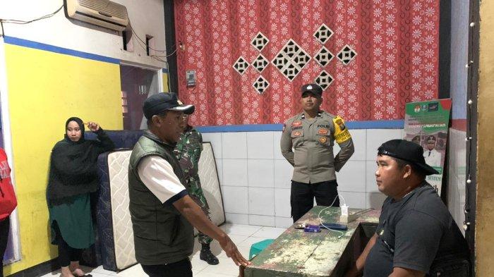 Kepala Desa Tomori, Kecamatan Bacan, Halmahera Selatan, Maluku Utara, Usman Hamzah (menggunakan rompi) ketika berbincang dengan salah satu penjaga penginapan saat pelaksanaan razia, Selasa (2/9/2024).