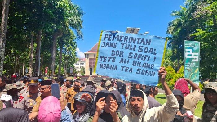 TUNTUTAN: Masyarakat Sofifi yang tergabung dalam Majelis Rakyat Sofifi (Markas) menggelar aksi damai di depan Kantor Gubernur Maluku Utara, Selasa (22/7/2025) dengan pamflet bertuliskan 'Pemerintah Jangan Tuli Soal DOB Sofifi, Tete Ali Bilang Ngana Tra Sopan'.