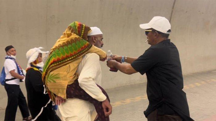 Seorang ibu asal Sindh Karachi, Pakistan digendong anaknya di Terowongan Mina.
