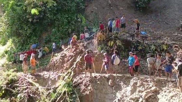 Warga Simbuang, Tana Toraja, melewati jalan yang tertutup longsor sambil membawa kerabatnya yang sakit dengan cara ditandu.