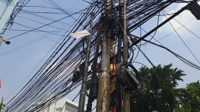 Ilustrasi kabel semrawut fiber optic yang berada di udara.