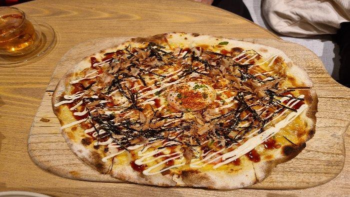 Menu Salmon Truffle Pizza yang ada di Cafe Kissa, Shinta Lobby, East Mall, Grand Indonesia, Jakarta. Salmon Truffle Pizza merupakan sajian pizza dengan taburan mirip okonomiyaki.