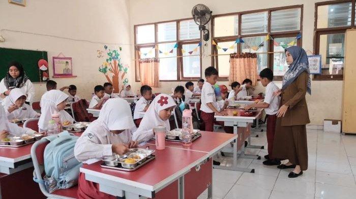 MAKAN BERGIZI GRATIS - Pelajar SD di Kota Depok tengah menyantap menu Makan Bergizi Gratis (MBG). Kepala Dinas Pendidikan Kota Depok, Siti Chaerijah Aurijah mendukung penuh program MBG.