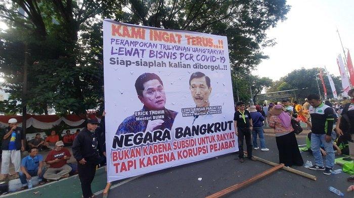 Dua spanduk besar milik buruh bergambar wajah Erick Thohir dan Luhut Binsar Pandjaitan dipasang di depan Patung Kuda, Kamis (10/8/2023).