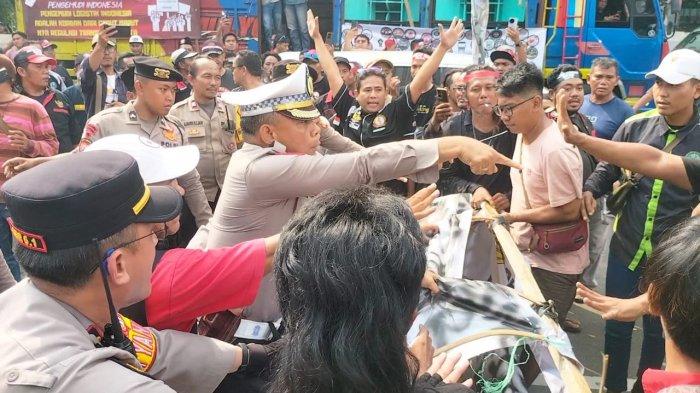 UNJUK RASA RICUH - Para sopir truk cekcok dengan polisi saat melakukan unjuk rasa terkait aturan nol kelebihan muatan dan dimensi atau Zero Overdimension Overload (ODOL) di Jalan Merdeka Selatan, Jakarta Pusat, Rabu (2/7/2025). Unjuk rasa berujung ricuh karena sopir truk ingin menutup jalan yang dicegah polisi.