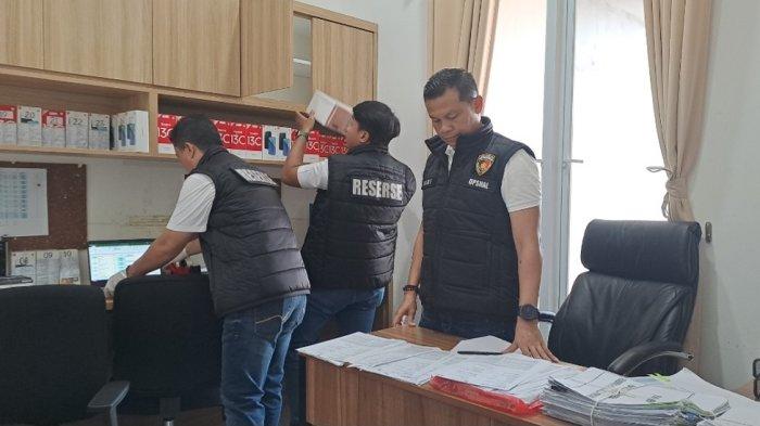 Polisi sedang mencari barang bukti di markas judi online.