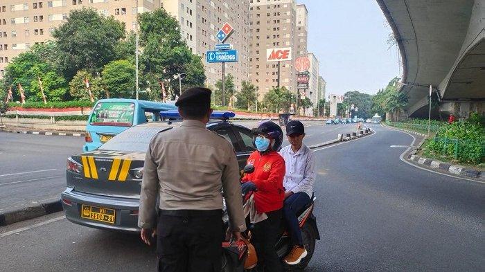 Polisi sedang menghentikan pengendara motor yang lawan arah.