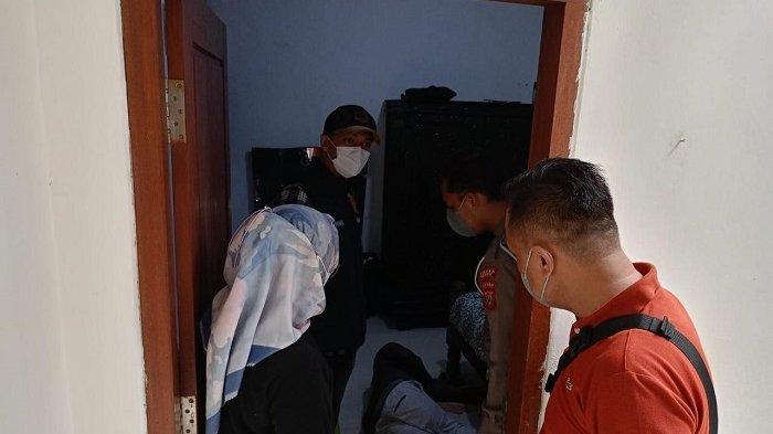 Serse Polsek Cisarua sedang mengevakuasi mayat WNA berkulit hitam dari sebuah rumah kontrakan.