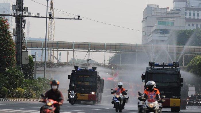 Satpol PP DKI Jakarta bersama polisi menyiram ruas jalan protokol dengan 'air limbah' jelang KTT ASEAN, Kamis (24/8/2023). Penyiraman itu dilakukan agar kualitas udara jadi bersih.