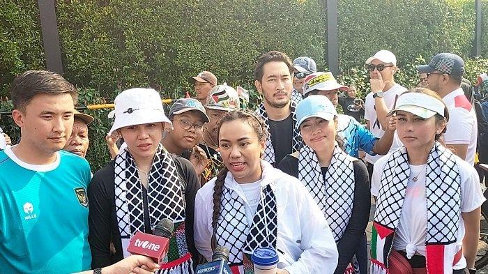 Wakil Ketua DPRD DKI Jakarta Zita Anjani (tengah) membagikan kopi produk lokal kepada masyarakat di Bundaran HI, Minggu (5/5/2024), sebagai bentuk dukungan pada Palestina.