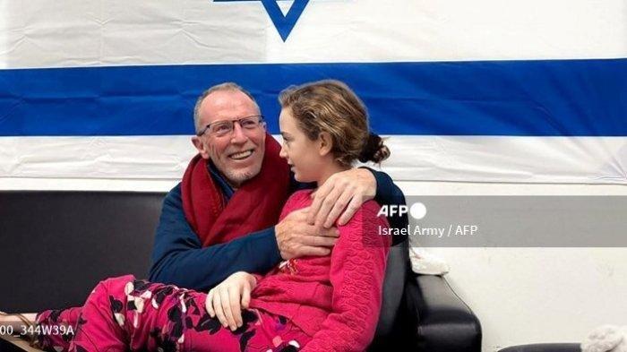 Gambar selebaran ini dirilis oleh tentara Israel, menunjukkan mantan sandera Irlandia-Israel berusia 9 tahun Emily Hand memeluk ayahnya di sebuah rumah sakit di Israel setelah dibebaskan oleh Hamas, di tengah operasi pertukaran sandera terhadap tahanan antara Hamas dan Israel, pada bulan November 26 November 2023. Hamas pada tanggal 25 November membebaskan kelompok kedua warga sipil Israel dan asing yang mereka sandera di Jalur Gaza dengan imbalan tahanan Palestina, setelah penundaan tak terduga selama berjam-jam yang membuat gelisah. Pihak berwenang Israel mengatakan 13 warga Israel dan empat warga negara Thailand telah kembali ke Israel.
