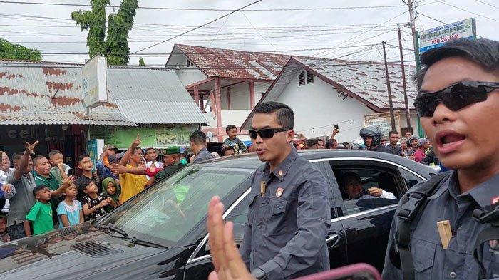 Presiden RI, Joko Widodo dari dalam mobil melempar baju kaos baru ke arah warga yang berdiri di tepi jalan Beureuenun, Pidie, Selasa (27/6/2023).