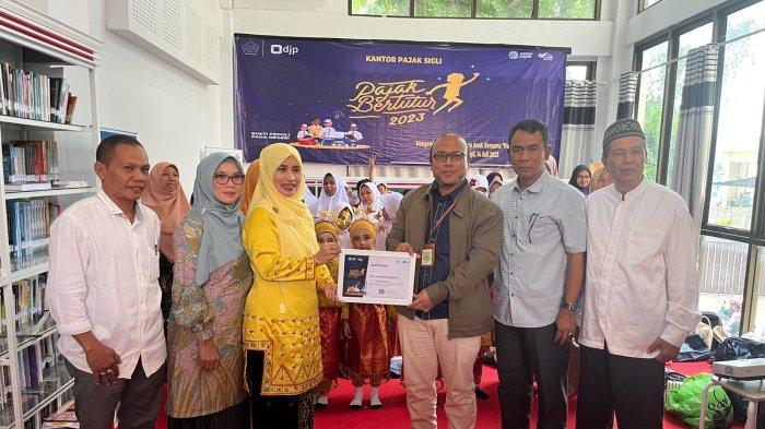 Kepala Kantor Pajak Sigli Lusi Wiratno menyerahkan cinderamata kepada Bunda Literasi Kabupaten Pidie Ny Suaidah Sulaiman dalam kegiatan Pajak Bertutur 2023 di Pustaka Bunda Literasi Sigli, Pidie, Jumat (14/7/2023).