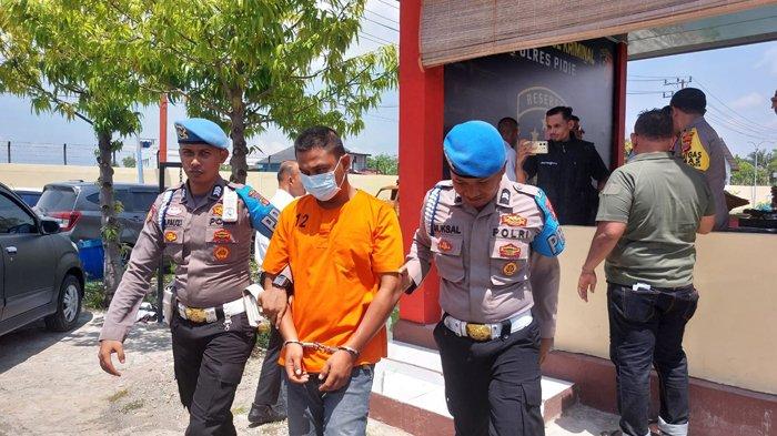 Tersangka pelaku penusukan saat didampingi petugas polisi setelah dihadirkan pada Konfrensi Pers di Mapolres Pidie, Senin (27/5/2024)