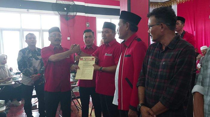 Calon Bupati Pidie, H Sarjani Abdullah didampingi Calon Wakil Bupati Pidie no urut dua, Alzaizi menyerahkan SK kepada Ketua Tim Pemenangan Tingkat Kabupaten, Mahfuddin Ismail SPdI MAP di Aula Sekretariat Partai Aceh Pidie, Selasa (29/10/2024).