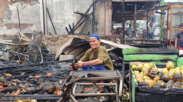 Seorang warga korban enam kios terbakar di Idi Rayeuk, Aceh Timur, Minggu (20/4/2025) terlihat mengumpulkan sisa   barang pasca musibah itu.