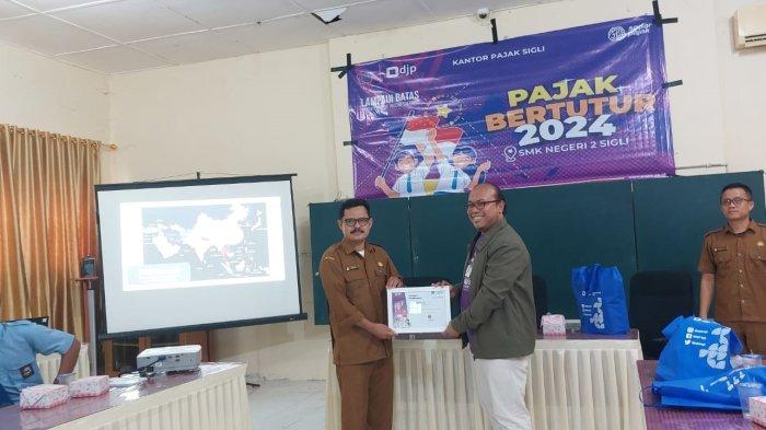 Kepala Kantor Pajak Sigli, Lusi Wiratno (kanan0 saat menyerahkan cinderamata kepada Kepala SMKN 2 Sigli, Isfandiar ST di acara Pajak Bertutur 2024, Rabu (7/8/2024).