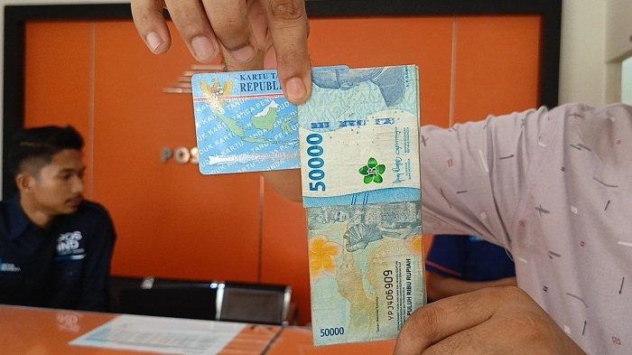 Penerima manfaat BSU Aceh Timur menunjukkan uang lembaran lima puluh ribu rupiah hasil cair BSU yang diambil di Pos Idi Rayeuk, Selasa (8/7/2025).