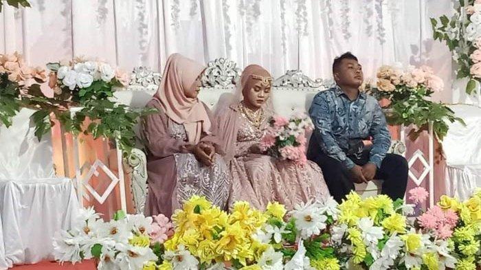 Pengantin wanita ditemani orang tua di pelaminan