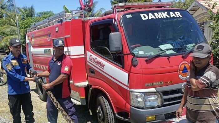 EVAKUASI ULAR PITON - Petugas BPBD Aceh Besar dibantu masyarakat menangkap ular piton sepanjang enam meter yang masuk selokan PAUD Al Zahra, Desa Baroh Blangme, Kecamatan Lhoong, Kamis (24/7/2025).