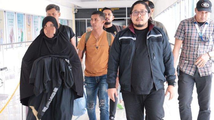 TANGKAP PELAKU TPPO - Petugas Satreskrim Polresta Banda Aceh membawa pelaku TPPO di Bandara Internasional Sultan Iskandar Muda (SIM) Blang Bintang, Aceh Besar usai ditangkap di Pekanbaru, Sabtu (21/6/2025).