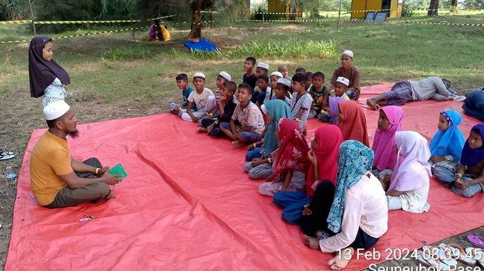 Anak-anak pengungsi etnis Rohingya di Gampong Kuala Parek, Kecamatan Sungai Raya, Aceh Timur, Minggu (18/2/2024), belajar mengaji dari seorang di antara para pengungsi itu, Muhammad Irfan, yang memiliki kemampun Hafiz 30 juz.