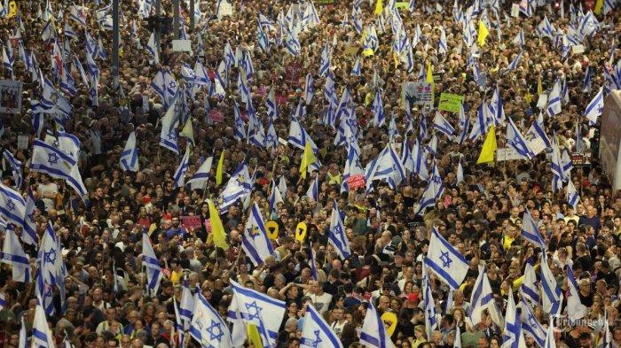 Ribuan pengunjuk rasa mengangkat bendera dan plakat selama unjuk rasa antipemerintah yang menyerukan pembebasan warga Israel yang disandera oleh militan Palestina di Gaza sejak Oktober, di Tel Aviv pada 1 September 2024. - Keluarga sandera Israel telah menyerukan pemogokan umum nasional yang dimulai pada malam 1 September untuk memaksa pemerintah mencapai kesepakatan guna mengamankan pembebasan tawanan yang masih ditawan di Gaza.