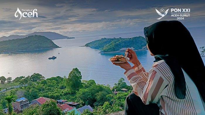 Pengunjung menikmati rujak khas Aceh sambil memandang keindahan laut dan Pulau Klah dari Puncak Pulau Klah, Sabang. Tempat ini terkenal dengan panorama yang indah, terutama saat matahari terbenam.