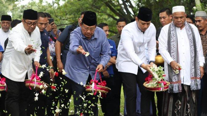 Mantan Presiden RI ke-6, Susilo Bambang Yudhoyono didampingi Ketum Demokrat, Agus Harimurti Yudhoyono, Sekjen Partai Demokrat, Teuku Riefky Harsya dan ulama melakukan tabur bunga saat ziarah di Kuburan Massal Siron, Kecamatan Ingin Jaya, Senin (25/12/2023).
