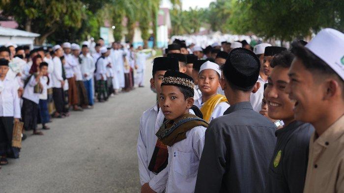 Para santri berbaris di pinggir jalan menyambut kedatangan calon gubernur Aceh nomor urut 1, Bustami Hamzah.