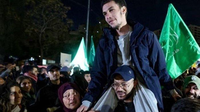 Seorang tahanan Palestina yang baru dibebaskan digendong dalam seremoni penyambutan tahanan yang dibebaskan dari penjara Israel dengan imbalan sandera Israel yang dibebaskan oleh Hamas dari Jalur Gaza, dalam sebuah upacara penyambutan di Ramallah, Tepi Barat yang diduduki, pada tanggal 28 November 2023. Layanan penjara Israel mengatakan bahwa 30 tahanan Palestina dibebaskan pada 28 November 2023 di bawah ketentuan perjanjian gencatan senjata antara Israel dan Hamas di Jalur Gaza. Pengumuman ini muncul setelah 10 sandera Israel dibebaskan di wilayah Palestina di bawah kesepakatan tersebut, bersama dengan dua warga negara Thailand.