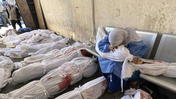 Seorang wanita Palestina tertunduk di atas jenazah seorang anak di antara jenazah-jenazah yang tewas akibat serangan Israel ke kamp pengungsi Jabalia, di Rumah Sakit Indonesia, di bagian utara Jalur Gaza, Sabtu, 18 November 2023.