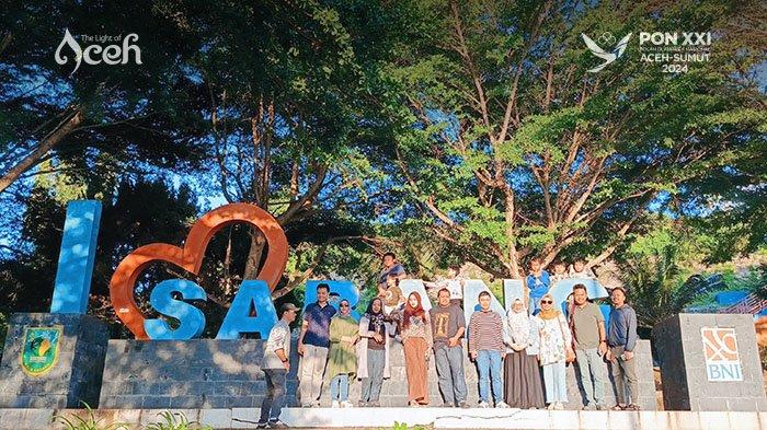 Wisatawan foto bersama di Taman I Love Sabang pada sore hari dengan latar pepohonan yang rindang.