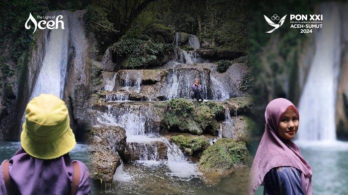 Wisatawan berswafoto dengan latar belakang Air Terjun Peucari, Jantho yang bertingkat-tingkat.