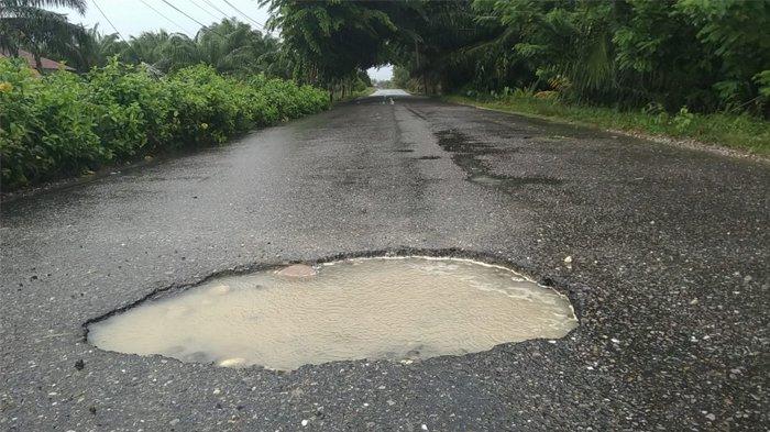 JALAN BERLUBANG: Lubang di Jalang Provinsi di kawasan Desa Suka Dami, Kecamatan Singkil, Kabupaten Aceh Singkil, tergenang air hujan yang mengguyur daerah itu, Jumat (1/8/2025)