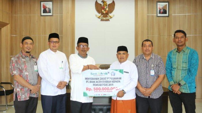 Pemimpin Bank Aceh Cabang Meureudu, Muhammad Reza Syahrizal (keempat kiri) didampingi staf menyerahkan dividen  PT Bank Aceh Syariah Tahun Buku 2023 kepada Pj Bupati Pijay Ir H Jailani Beuramat yang juga didampingi Kepala BPKK Pidie Jaya, Teuku Muslim dan staf, Selasa (11/6/ 2024) di ruang kerja Pj Bupati Pidie Jaya