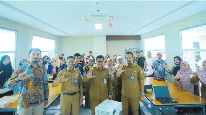 Kepala Dinas Perpustakaan dan Kearsipan Aceh, Dr Edi Yandra MSP, didampingi dua pejabat dinas tersebut saat foto bersama dengan para peserta Pelatihan Desain Brands Produk untuk Para Pelaku UMKM tahun 2023 di Ruang Klinik Inklusi Sosial kantor tersebut.