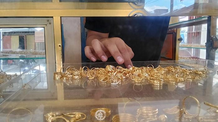PENJUAL EMAS - Pedagang emas di Kota Kualasimpang, Aceh Tamiang menyusun koleksinya, Rabu (16/7/2025). Harga emas relatif stabil dan cenderung terjadi peningkatan aksi jual oleh masyarakat. SERAMBINEWS.COM.RAHMAD WIGUNA