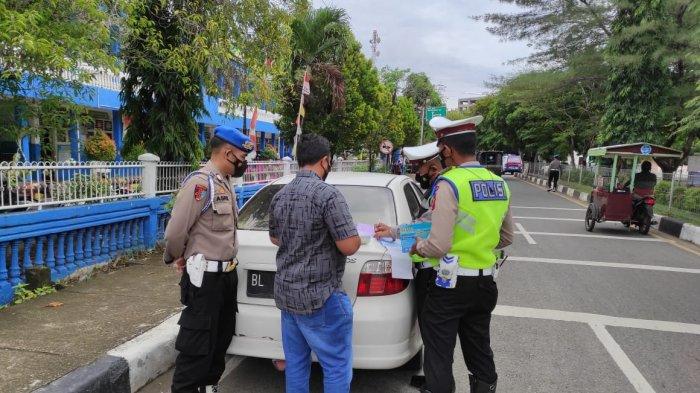 Personel Polres Pidie tilang roda empat yang parkir sembarangan di pinggir jalan dalam Operasi Keselamatan Seulawah 2022 di seputaran Kecamatan Kota Sigli, Kamis, (10/03/2022).