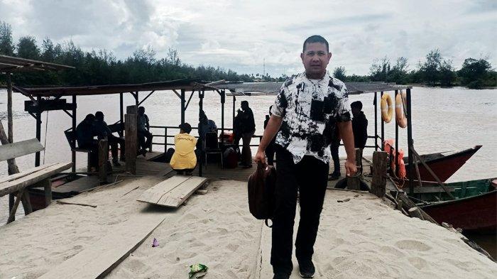 Penulis, Hasan Basri M Nur, berfoto di depan dermaga penyeberangan rakit yang menghubungkan Kecamatan Kuala Baru dengan Kecamatan Singkil, Selasa (18/7/2023).