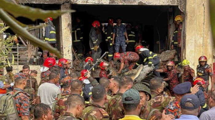Petugas pemadam kebakaran memeriksa reruntuhan jet tempur jatuh di Bangladesh yang mengenai sebuah sekolah di Dhaka, Bangladesh, Senin, 21 Juli 2025.