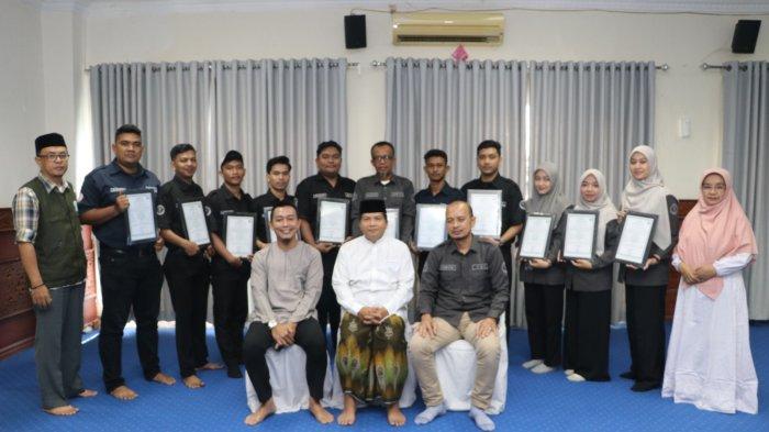 SERAHKAN SERTIFIKAT HALAL - Ketua MPU Aceh, Tgk H Faisal Ali, menyerahkan sertifikat halal kepada CEO Kutaradja Fried Chicken, Robi Erianto SP, di Kantor MPU Aceh, Jumat (21/2/2025).