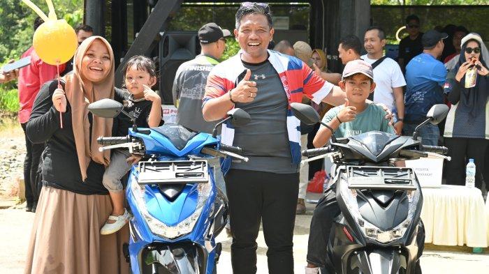Lisa warga Gampong Buloh sambil menggendong anaknya berhasil mendapatkan grand prize sepeda motor dari trail run and bike