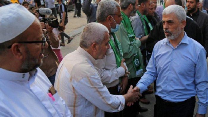 Orang nomor dua Hamas, Yahya Sinwar (kanan), yang rumahnya menjadi sasaran serangan udara Israel, menyapa pendukungnya di Kota Gaza pada Sabtu (22/5/2021)