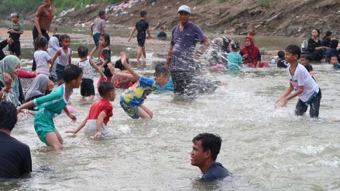 PANTAI BARU - Masyarakat antusias mengunjungi “pantai dadakan” yang muncul akibat surutnya air Sungai Tamiang, Sabtu (26/7/2025).