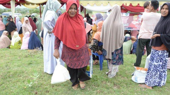 Warga membawa pulang sembako murah usai berbelanja di pasar murah yang digelar Pemkab Aceh Besar dan Perum Bulog Kanwil Aceh di halaman Masjid Al-Ikhlas, Gampong Meureu, Kecamatan Indrapuri, Aceh Besar, Selasa (15/08/2023) siang.