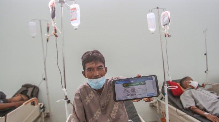 Indra Syahputra (46) pasien Thalasemia sedang menunjukkan kartu JKN di Rumah Sakit Umum Daerah dr Zainoel Abidin (RSUDZA) Banda Aceh, Senin (28/8/2023)