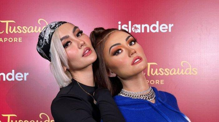 Penyanyi Agnez Mo berpose bersama patung lilin dirinya yang baru diperkenalkan oleh Madame Tussauds Singapura.